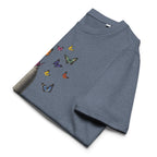 A folded heather gray t-shirt featuring a colorful butterfly print on the front, displayed on a clean white background.
