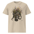 A beige crewneck t-shirt featuring a Wry Bird graphic print of a dark metal gas mask filled with an assortment of colorful wildflowers, shown against a plain white background.