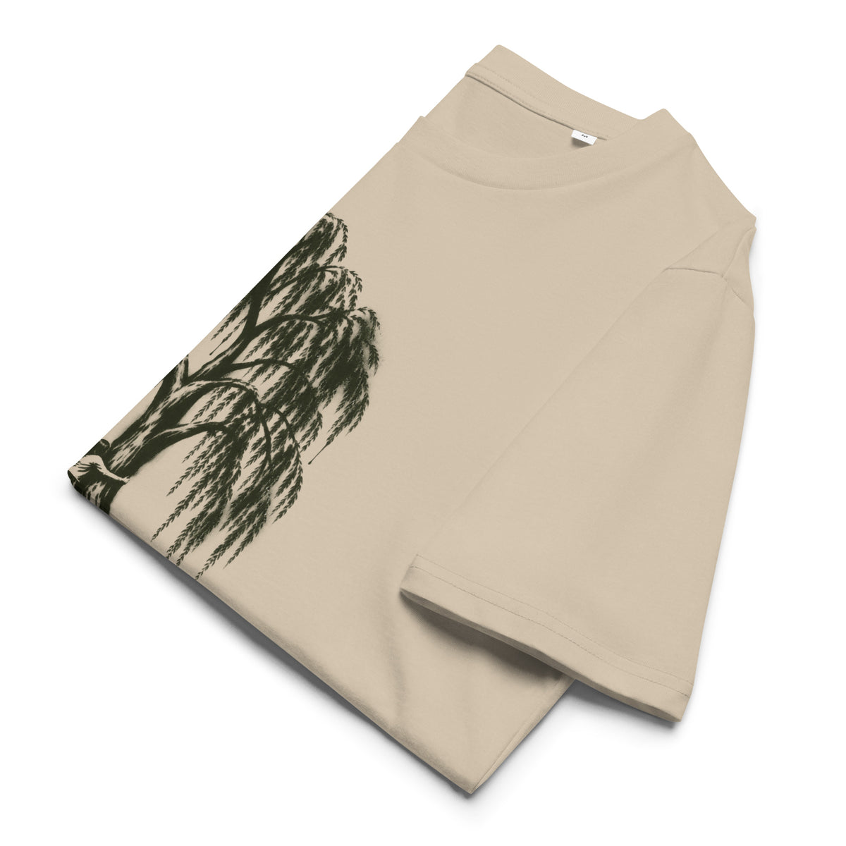 A beige short-sleeve t-shirt with a dark green/black ink-style illustration of a weeping willow tree, shown folded on a white background.