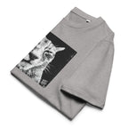 A folded heather gray Wry Bird t-shirt featuring a large black and white graphic print of a cat's face on the front, displayed on a clean white background.
