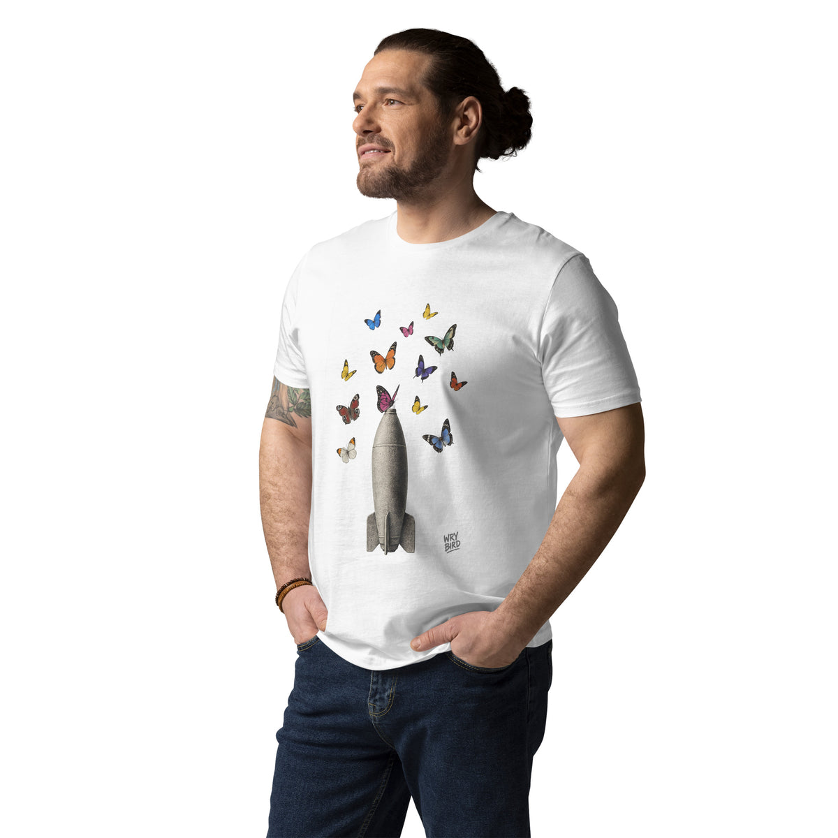 A man wearing a white crewneck t-shirt with a graphic of an old bomb with colorful butterflies, paired with dark blue jeans, against a plain white background.